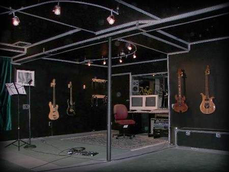 Recording studio live room with track lighting, instruments on the walls and the control desk