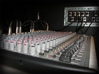 Close view of a mixing console with the studio jack panel behind it