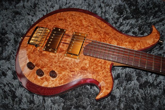 Burl-top guitar with gold pickups and wooden knobs