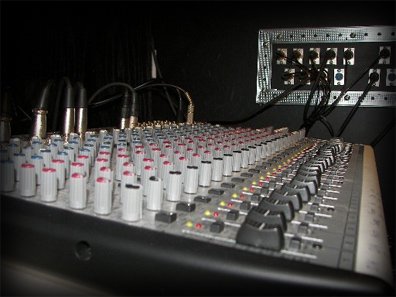 Mixing console with the studio jack panel behind it